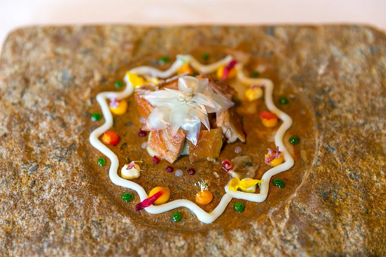Fine-dining tasting course — a mandala of milk-fed lamb, artichoke, curry yoghurt, and edible flowers