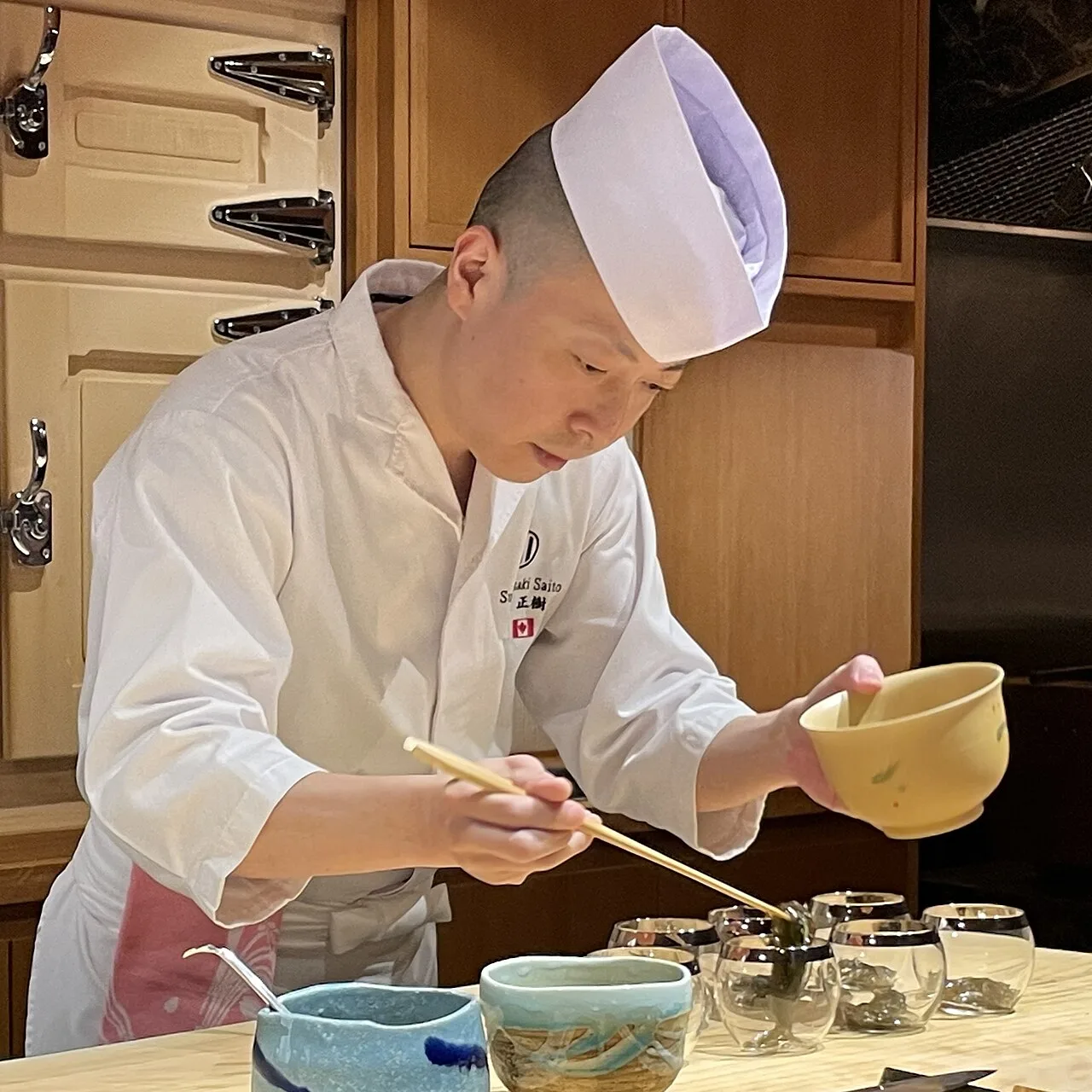 Chef Masaki Saito preparing a course at Sushi Masaki Saito, Toronto