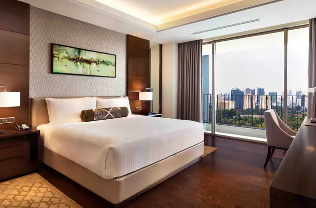 King bed and balcony outlook in a Fairmont Jakarta room