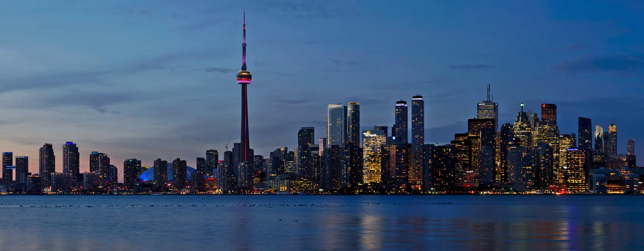 Toronto skyline and CN Tower across the harbour at sunset