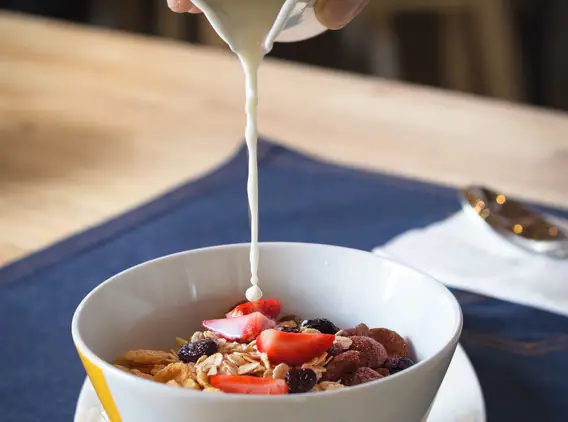 Milk poured over a granola bowl at Yello Hotel Kuta Beachwalk